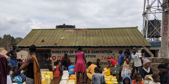 Kibera, Nairobi, Kenia Viele Leute mit Wassercontainern, die vor einem neu errichteden Wasserkiosk im Stadtteil Kibera in Nairobi warten
